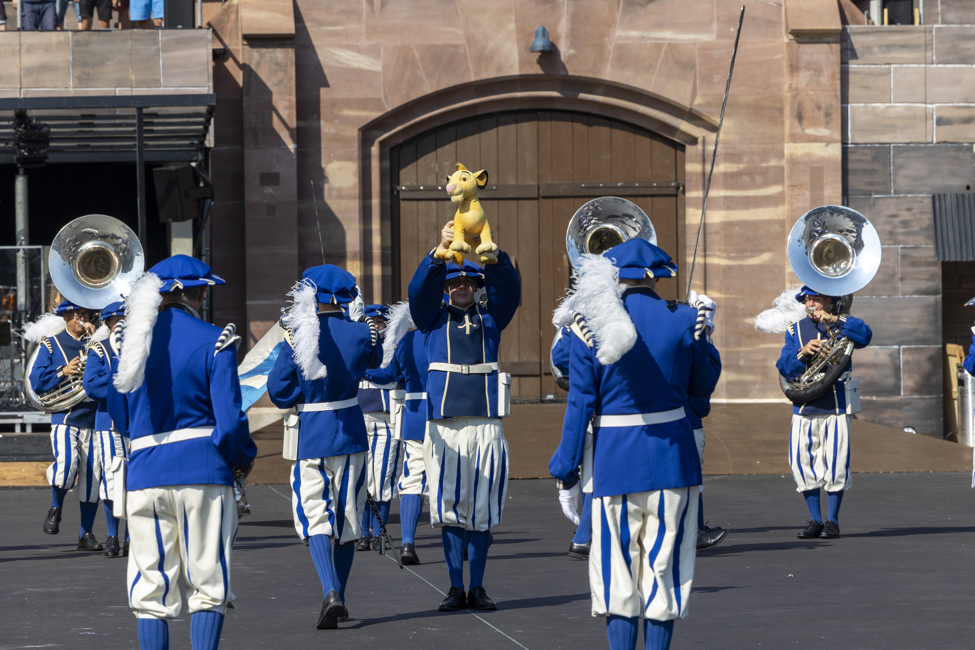 The Lucerne Marching Band  mit einem Löwenstofftier in der Hand stehend in der Kaserne Basel